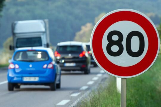 Photo d'un panneau de signalisation 80 km/h aux abords d'une route départementale